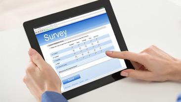 Consultation: the hands of a woman hold a digital tablet showing a survey form
