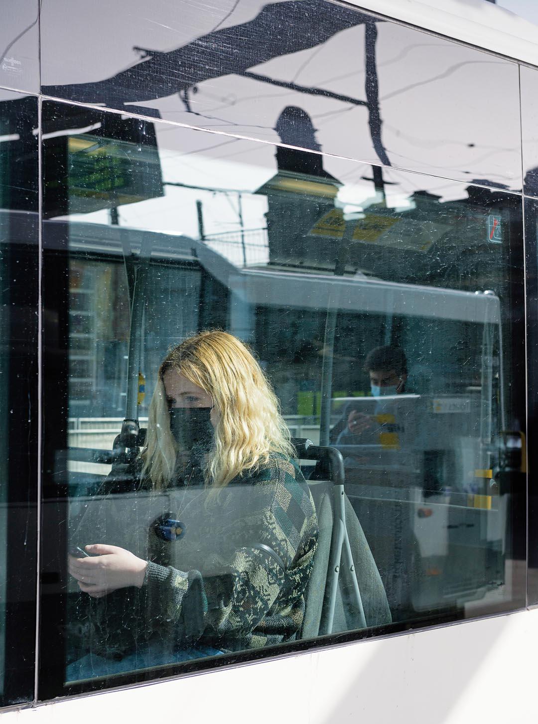 Een meisje bekijkt haar GSM op de bus