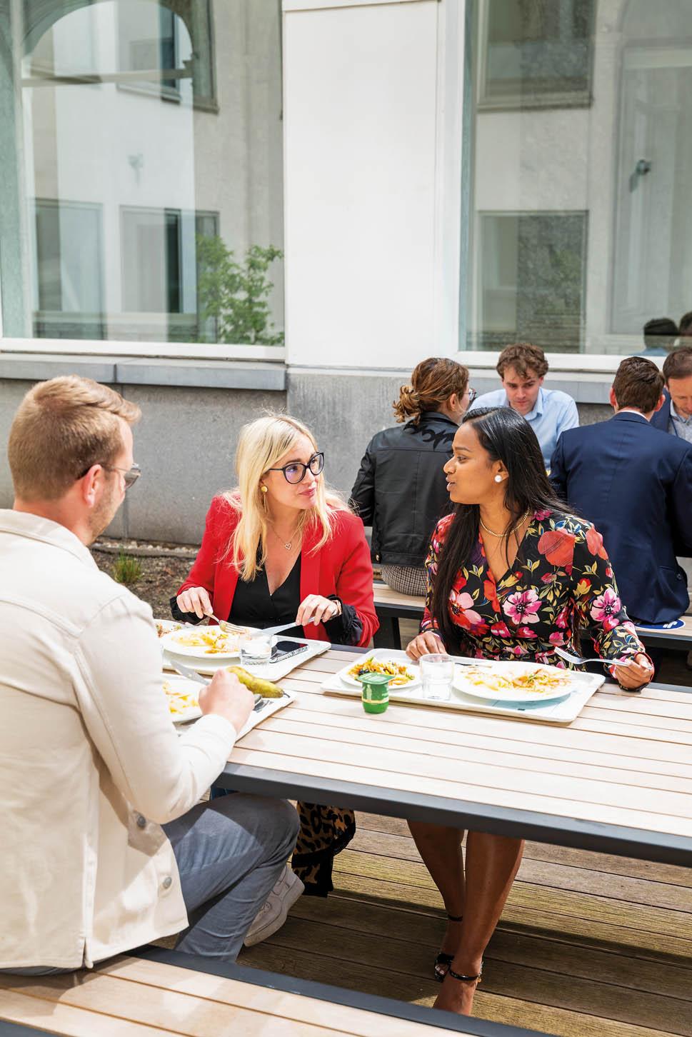 FSMA-medewerkers eten lunch aan tafels op een binnenplaats