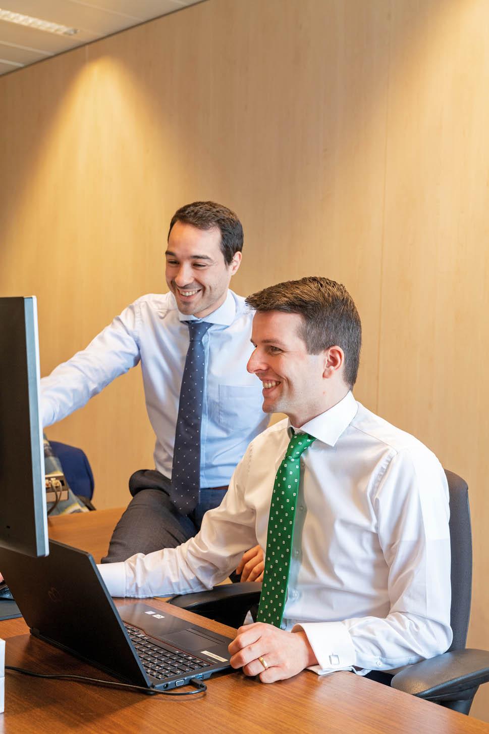 Twee FSMA-medewerkers werken samen op een computer