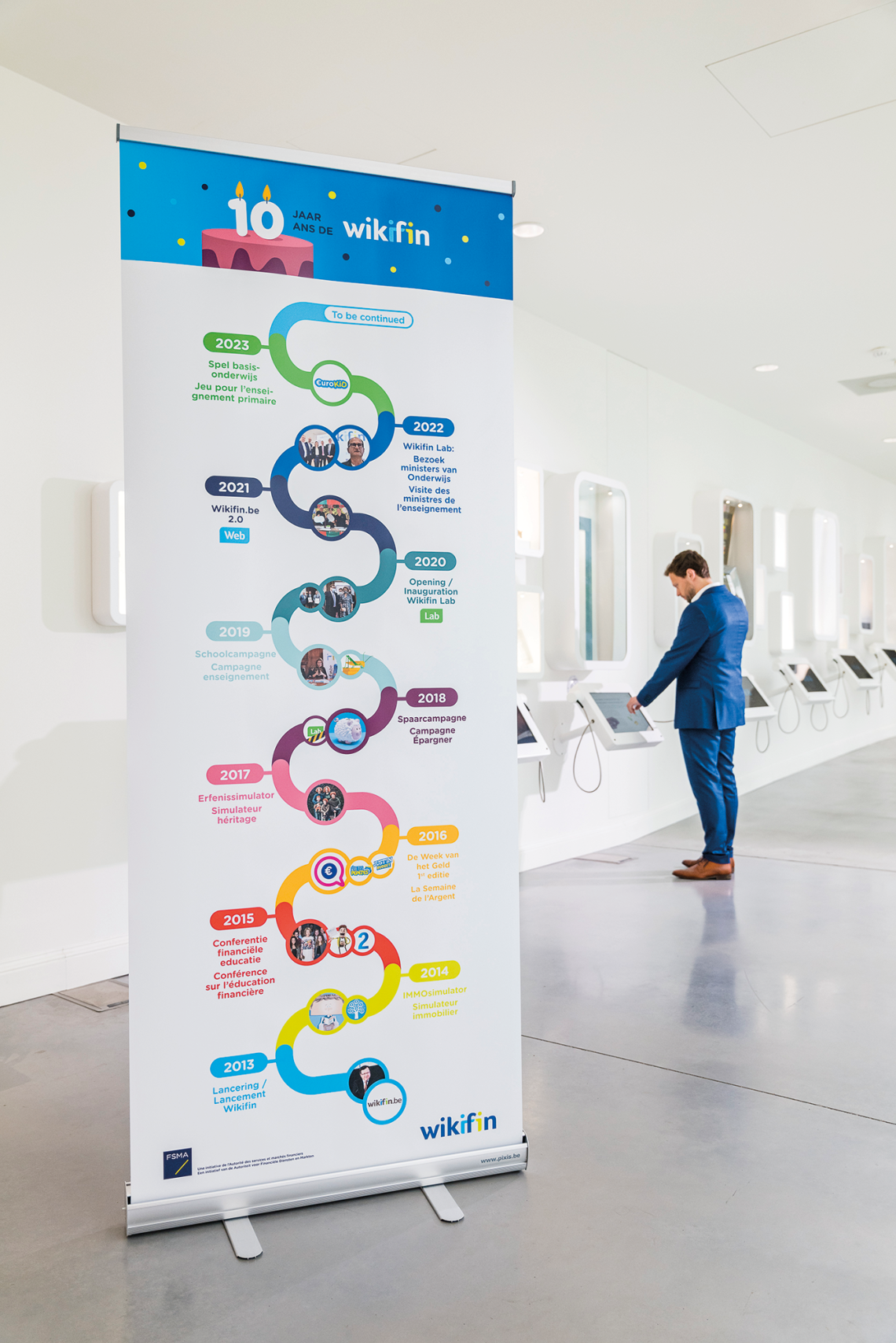 Een FSMA-medewerker aan de kennismuur in het Wikifin Lab, banner 10 jaar Wikifin