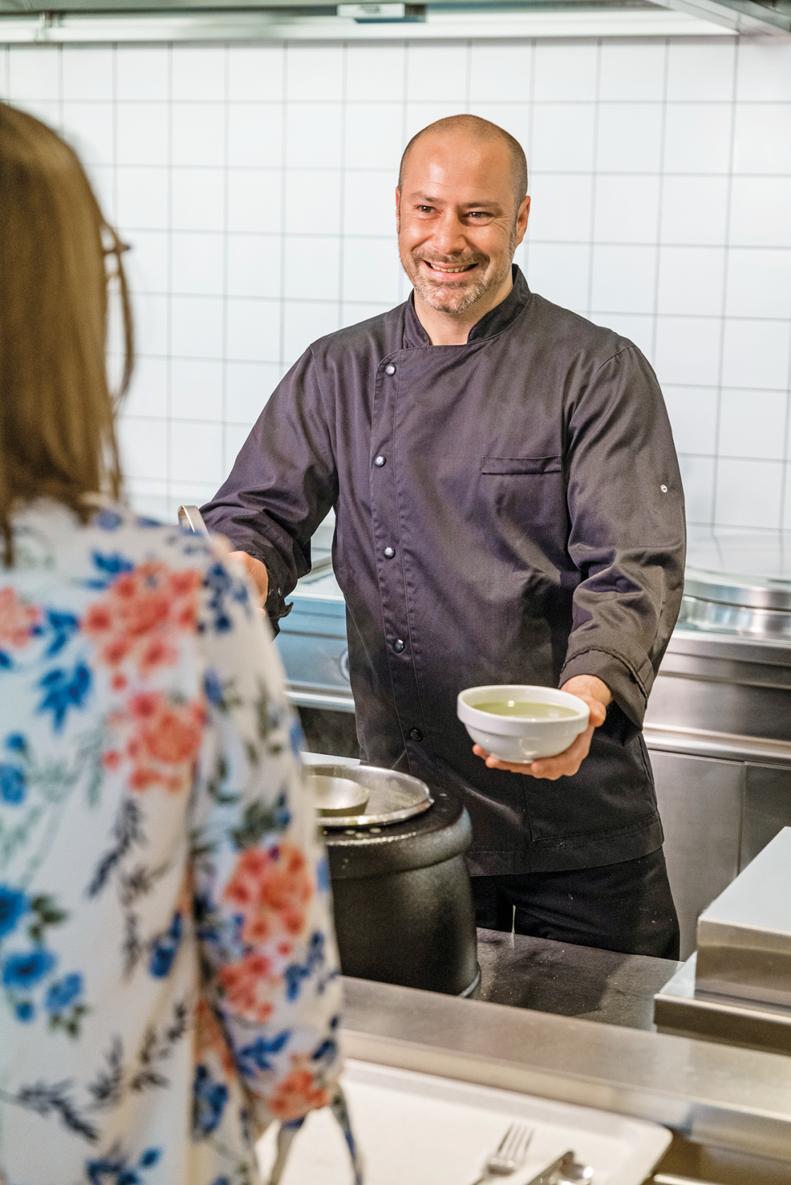 Een FSMA-medewerkster deelt soep uit in het bedrijfsrestaurant