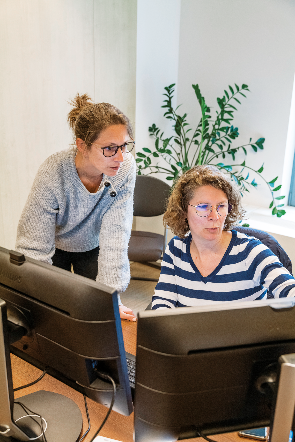 Twee FSMA-medewerkers werken samen op een computer