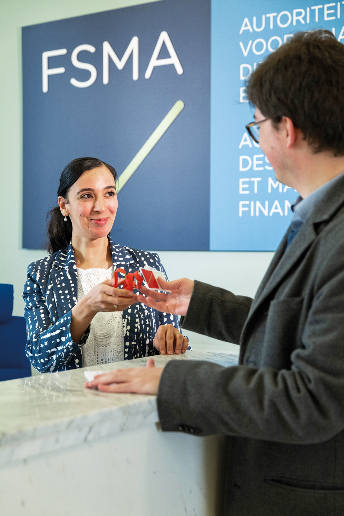 Bezoeker aan de FSMA-receptie wordt onthaald door een FSMA-medewerkster