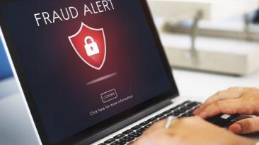 Warning: a fraud warning appears on a laptop screen