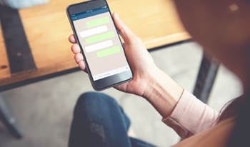 Man holding a phone that shows a conversation