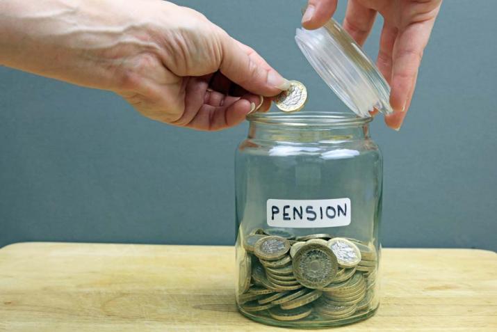 Pensioenen: een hand die een muntstuk in een pot steekt voor zijn pensioen
