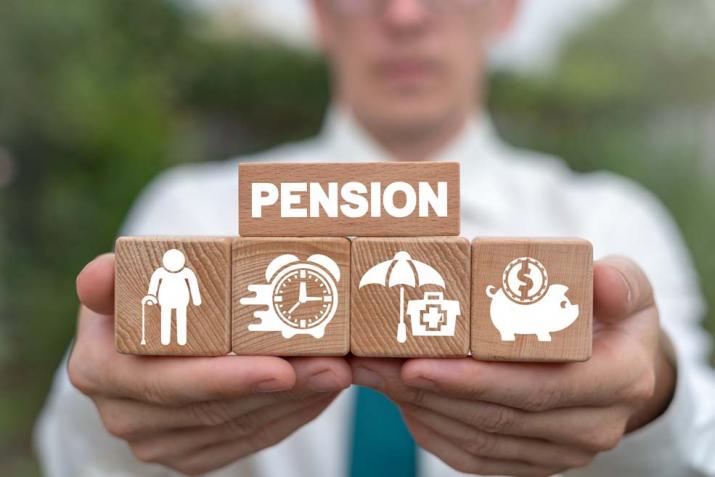 Pensioenen: een man toont het concept van pensioenplanning aan de hand van blokken: pensioensparen, ouderen financieren, gezondheid en veiligheid