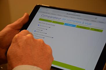 Wikifin: hands of a man using the cost comparison tool for current accounts on an iPad