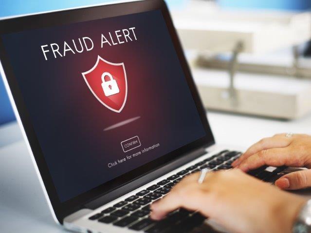 Warning: a fraud warning appears on a laptop screen