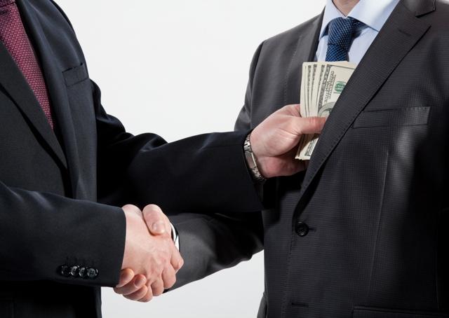 Recovery room: two men shake hands while one man puts money in the pocket of the other man's suit