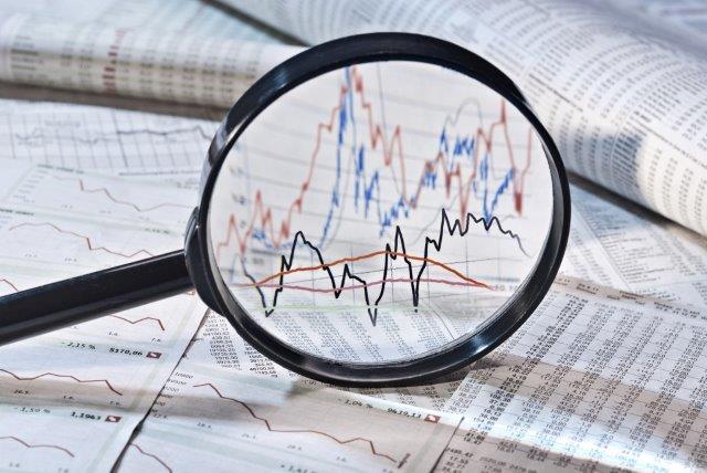 Shadow banking: a magnifying glass shows graphs in a newspaper